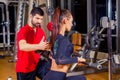 Fitness, sport, training and people concept - Personal trainer helping woman working with in gym Royalty Free Stock Photo