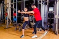 Fitness, sport, training and people concept - Personal trainer helping woman working with in gym Royalty Free Stock Photo