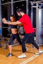 Fitness, sport, training and people concept - Personal trainer helping woman working with in gym Royalty Free Stock Photo