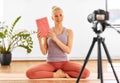 Woman with camera streaming for yoga blog at home Royalty Free Stock Photo
