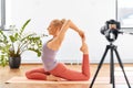 Woman with camera streaming for yoga blog at home Royalty Free Stock Photo