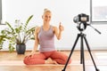 Woman with camera streaming for yoga blog at home Royalty Free Stock Photo