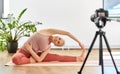 Woman with camera streaming for yoga blog at home Royalty Free Stock Photo