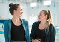 Fitness, sports and woman swimmer friends by a pool in the gym together for health, training or exercise. Teamwork Royalty Free Stock Photo