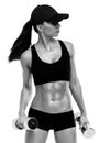 Fitness sporty woman in training pumping up muscles with dumbbells