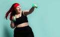 Fitness spring diet weight loss concept. Lucky plus-size girl overweight woman dieting working out with green weights dumbbells Royalty Free Stock Photo