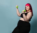 Fitness spring diet weight loss concept. Self-confident plus-size overweight woman does exercises with weights dumbbells