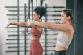 Fitness, stretching and arms with women in gym for training, workout and exercise. Teamwork, health and personal trainer