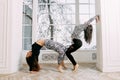 Fitness, stretching practice, group of two attractive women doing yoga. Wellness concept Royalty Free Stock Photo