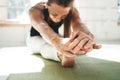 Fitness strong woman bending forward stretching her leg sitting on yoga mat Royalty Free Stock Photo