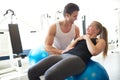 Fitness Trainer Assisting a Woman on Exercise Ball Royalty Free Stock Photo