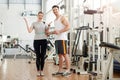 Fitness trainer measuring female waist at gym. Royalty Free Stock Photo