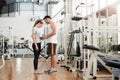 Fitness trainer measuring waist of female client.