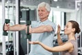 Fitness Trainer with Senor Client in Gym