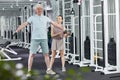 Fitness Trainer with Senor Man in Gym