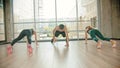 Fitness training in the studio - Two women and their coach leaning on the ground and crawling forwards - standing up and