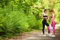 Fitness. Two female runners stretching legs outdoors in park in summer Royalty Free Stock Photo