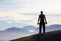 Fitness, weightlifting and back of man with dumbbells on mountain top for morning cardio on sky background. Weights