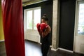 Fitness woman boxer in tight-fitting black sportswear and red boxing gloves training in a boxing gym, making a straight punch Royalty Free Stock Photo