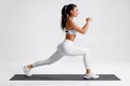 Fitness woman doing lunges exercises for leg muscle training. Active girl doing front forward one leg step lunge exercise Royalty Free Stock Photo