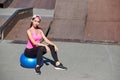 Fitness woman doing stretching exercises with fit ball on urban city background Royalty Free Stock Photo