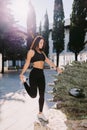 Fitness woman doing stretching legs exercise outdoors. Female in sportswear