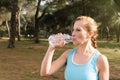 Fitness woman drinking a bottle of water while doing sports outdoors Royalty Free Stock Photo