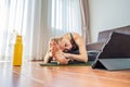 Fitness woman exercising on the floor at home and watching fitness videos in a tablet. People do sports online because Royalty Free Stock Photo