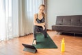 Fitness woman exercising on the floor at home and watching fitness videos in a tablet. People do sports online because Royalty Free Stock Photo