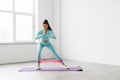 Fitness woman exercising fitness resistance bands on mattress on white background