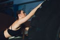 Fitness woman flipping wheel tire in gym. Fit female athlete working out with a huge tire. Back view. Sportswoman doing Royalty Free Stock Photo