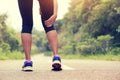 Fitness woman jogger hold her sports injured leg at forest trail Royalty Free Stock Photo