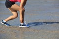 Fitness woman jogger hold her sports injured leg at seaside Royalty Free Stock Photo