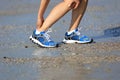 Fitness woman jogger hold her sports injured leg at seaside Royalty Free Stock Photo