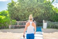 Fitness woman listening to music in sportswear with wireless in-ear headphones on summer ocean beach in Miami