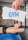 Fitness woman lying over exercise ball with hand holding text with placard Royalty Free Stock Photo