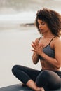 Fitness woman meditating outdoors while sitting on mat. Healthy female with her hands joined Royalty Free Stock Photo