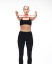 Fitness woman performs exercises for the muscles of the hands with resistance band Royalty Free Stock Photo