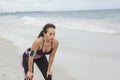 Fitness Woman resting after work out on the beach at cloudy winter day Royalty Free Stock Photo