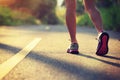 fitness woman runner legs running on morning tropical