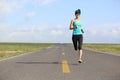 Fitness woman runner running on road