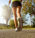 Fitness woman running on asphalt road at sunset Royalty Free Stock Photo