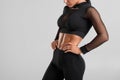 Fitness woman showing abs and flat belly, isolated on gray background. Beautiful athletic girl, shaped abdominal Royalty Free Stock Photo