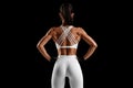 Fitness woman showing back muscles on black background. Athletic girl rear view Royalty Free Stock Photo