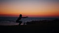 Fitness woman in silhouette doing squats exercises on beach near ocean. Young female in sportswear spending evening time Royalty Free Stock Photo