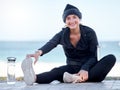 Fitness, woman and stretching legs by beach in preparation for exercise, cardio workout or training. Portrait of happy Royalty Free Stock Photo