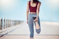 Fitness, woman and stretching legs at beach promenade for exercise, wellness and training. Back of athlete, runner and Royalty Free Stock Photo