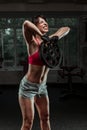 Fitness woman swinging kettle bell at gym