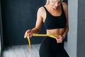 Athletic slim woman measuring her waist by measure tape Royalty Free Stock Photo