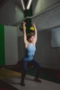 Fitness woman training by kettlebell. Fit young lady doing crossfit exercise.